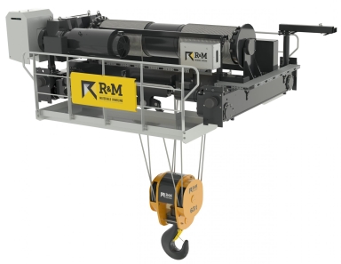 Industrial crane lifting heavy equipment in a warehouse
